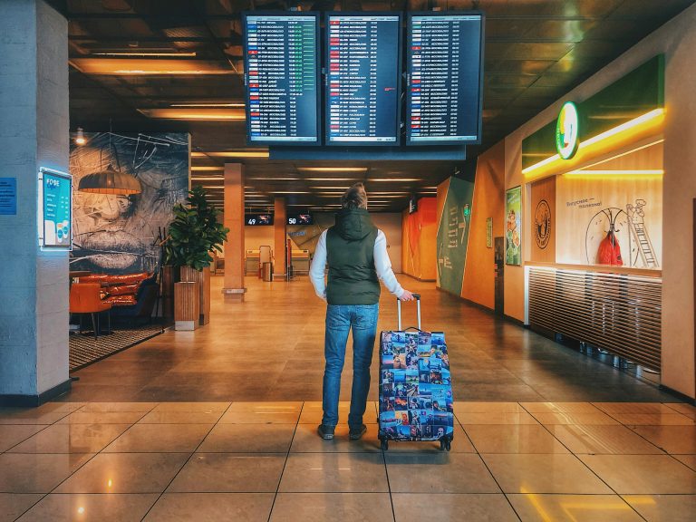 Traveler with backpack walking through airport during flight layover